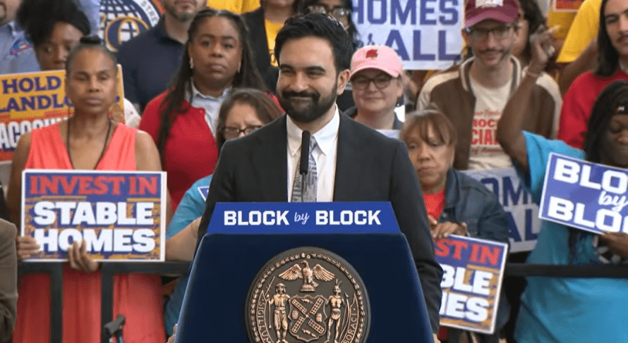Mayor Mamdani standing in front of a crowd of supporters to announce his administration's housing plan, Block by Block