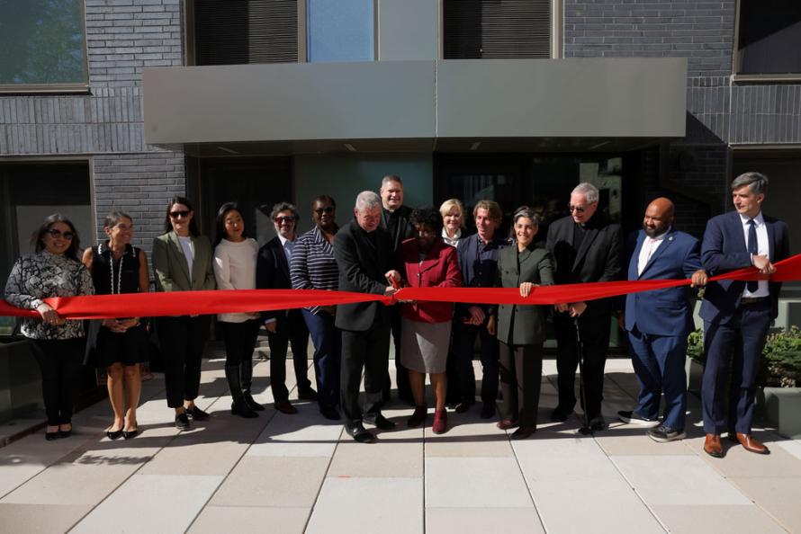 public and private partners cutting the ribbon on on a new affordable housing development, standing in a line. 